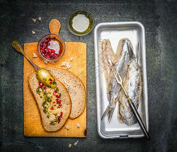 腌制的鲱鱼三明治与红色洋葱酱旧的切割板,顶部视图鱼的食物图片