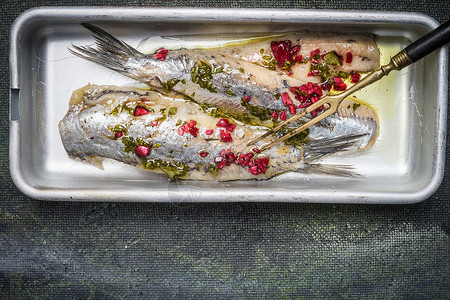 腌制鲱鱼与草药碗与腌鱼叉子乡村背景,顶部视图鱼的食物背景图片