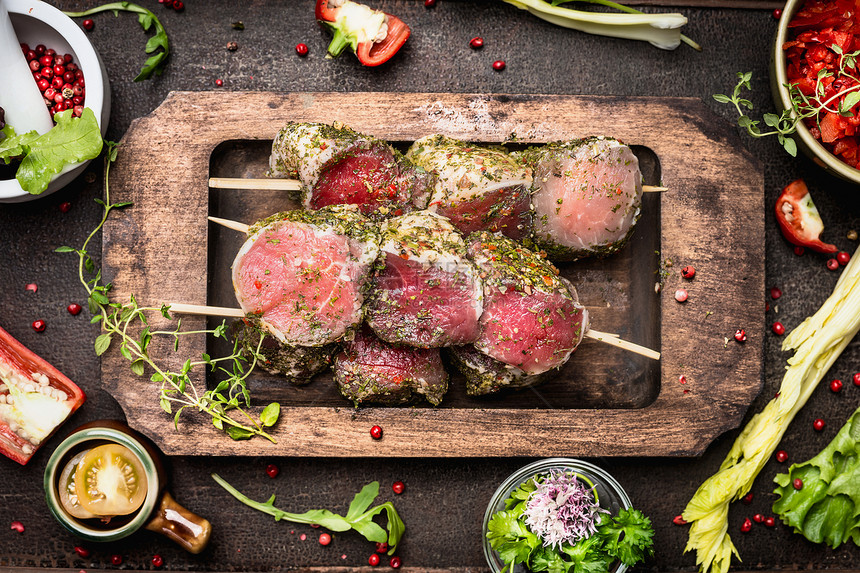 肉串与绿色草药外壳烤架烹饪,准备黑暗的乡村木制背景,顶部视图图片