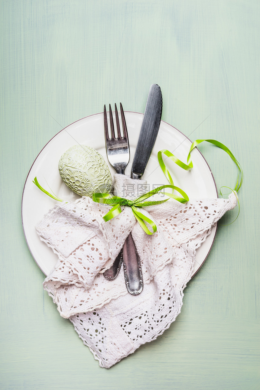 复活节餐桌与餐具鸡蛋装饰浅绿色背景,顶部视图图片
