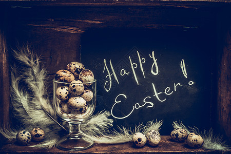 快乐复活节贺卡与鹌鹑蛋璃黑板上的乡村木制背景,侧视图片