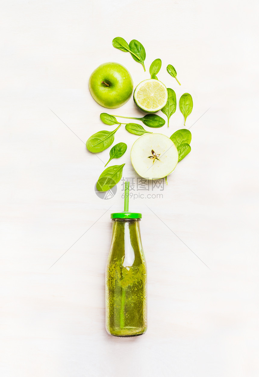 绿色冰沙饮料瓶与吸管配料菠菜,苹果,石灰白色木制背景,顶部视图图片
