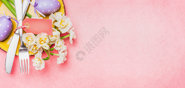 复活节餐桌春花,装饰鸡蛋餐具浅粉色背景,顶部视图,文字,横幅图片
