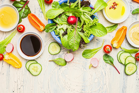 新鲜蔬菜沙拉,各种敷料轻乡村背景,顶部视图,边界健康的生活方式素食饮食的图片