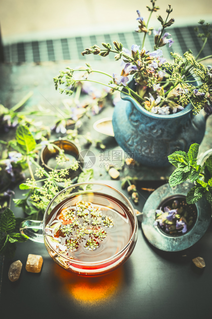 杯草药茶,窗边的桌子上放着新鲜的治疗草药野花健康,愈合排饮料的图片
