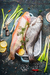生全鳟鱼金虹鳟鱼菜肴与冰块新鲜的烹饪成分黑暗的乡村背景,顶部视图健康饮食的食物背景图片