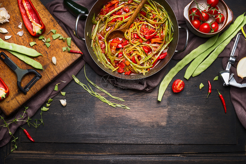 绿豆与番茄酱烹饪锅与配料砧板上的素食菜肴黑暗的乡村木制背景,顶部的视图图片