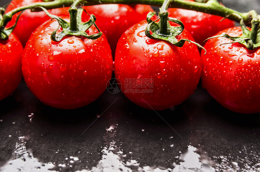 红色成熟湿西红柿,水滴黑暗的石板背景上,图片