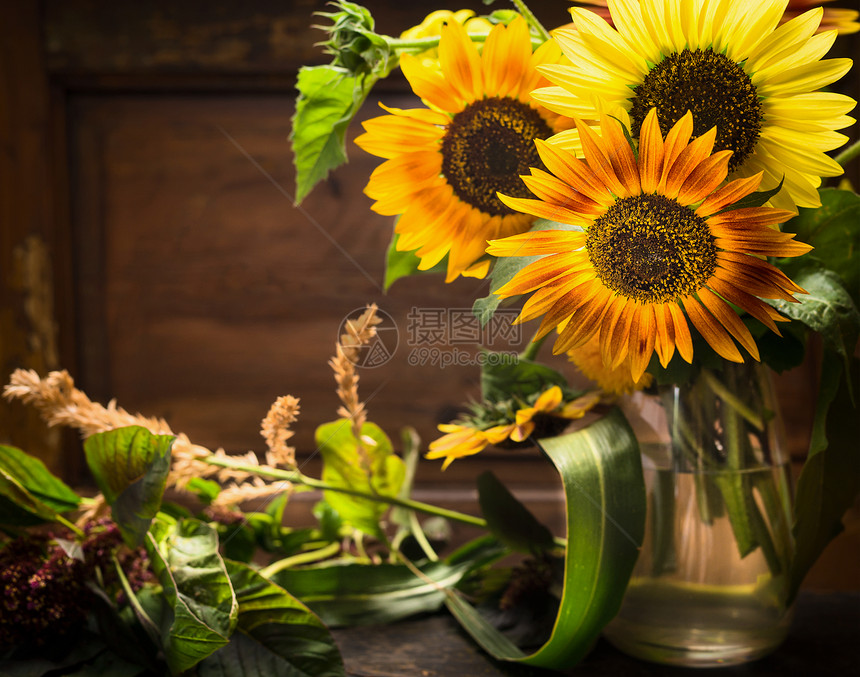 木制背景上桌子上花瓶里的向日葵,静物图片