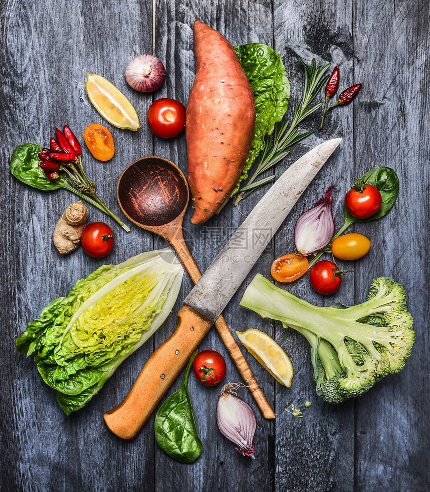 生机蔬菜的选择与菜刀木勺健康烹饪的原料蓝色乡村木制背景,顶部视图图片