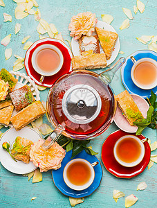 茶歇与杯子,花,蛋糕茶壶浅蓝色背景,顶部的视图图片