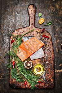 新鲜美味的三文鱼鱼片,配以莳萝油配料,用于乡村砧板上烹饪,木制背景,顶部景观图片