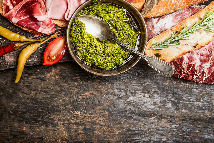 绿色Pesto肉盘与包反腹乡村木制背景,顶部视图,边界意大利食品图片