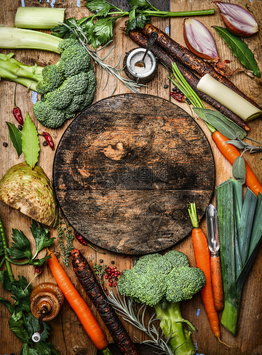 新鲜机蔬菜成分汤肉汤周围的圆形乡村空白切割板,顶部视图健康食品素食烹饪图片