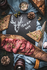 鹿肉火腿与包服务树皮与菜刀,顶部视图图片