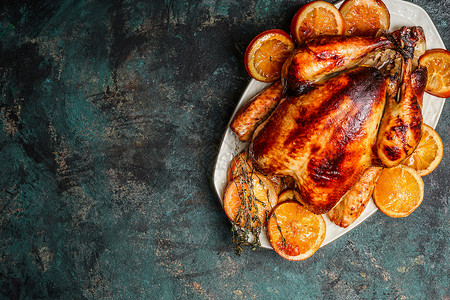 烤全火鸡鸡肉盘子与烤橙黑暗的乡村背景图片