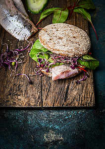 健康的鱼三明治与谷物包鱼乡村砧板上图片