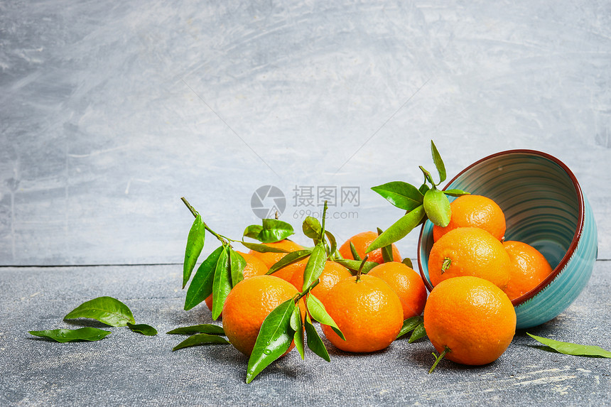 橘子与绿叶碗乡村背景,侧视图片