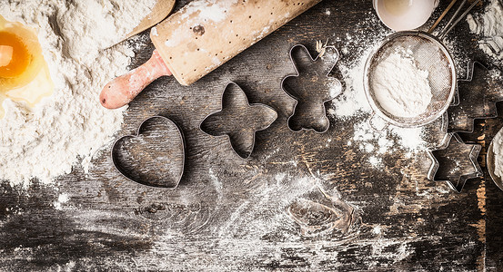 粉钻边框诞烘焙粉,蛋黄,擀杖,深色木制背景上的饼干切割机,顶部视图,边框背景