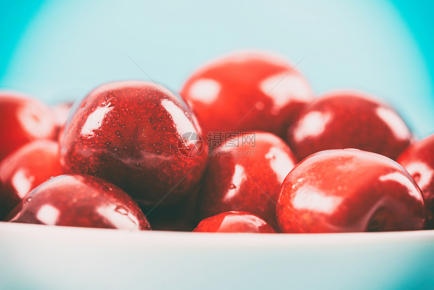白色碗新鲜的红色樱桃图片