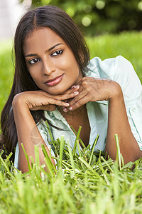 户外肖像个美丽的印度亚洲轻妇女女孩夏天的阳光下躺她的手上图片