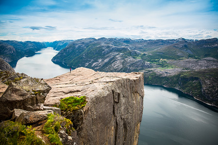 自然摄影师游客与相机拍摄,同时站山顶美丽的自然,挪威的前客前客图片