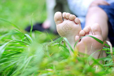 小男孩的脚踩新鲜的草地上图片