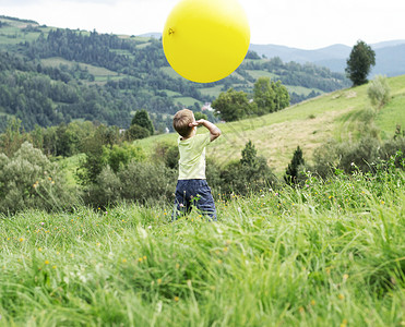 小男孩玩个巨大的黄色气球图片