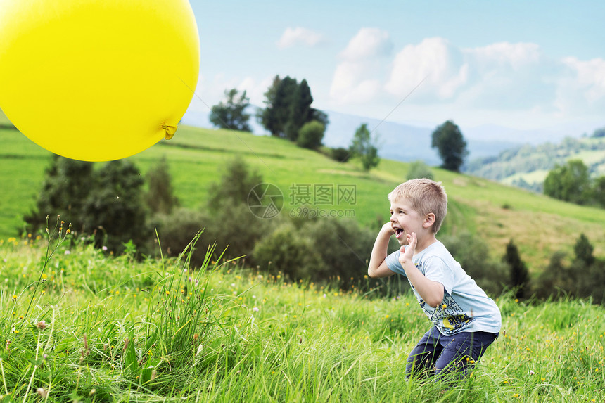 快乐的男孩弹着个气球图片