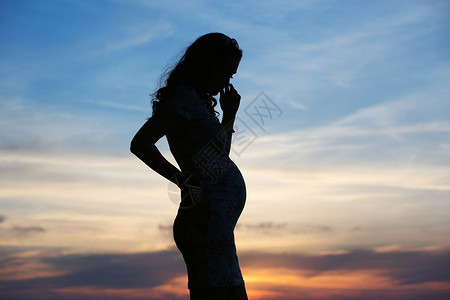 生育能力轻孕妇的剪影背景