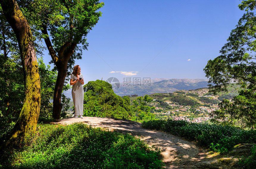 风景优美的妇女观看日落山,佩内达格雷斯公园,葡萄牙北部图片