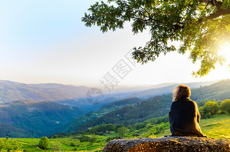 风景优美的妇女观看日落山,佩内达格雷斯公园,葡萄牙北部背景图片