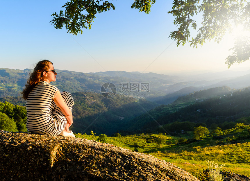 风景优美的妇女观看日落山,佩内达格雷斯公园,葡萄牙北部图片