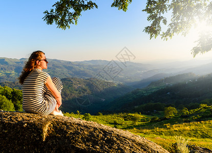 风景优美的妇女观看日落山,佩内达格雷斯公园,葡萄牙北部图片