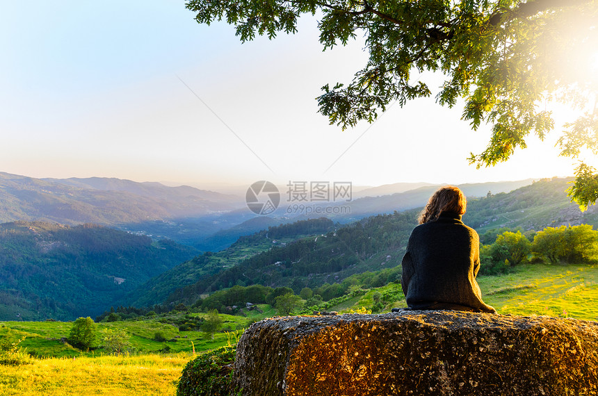 风景优美的妇女观看日落山,佩内达格雷斯公园,葡萄牙北部图片