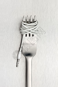 个闪亮的叉子与条制成的电缆与音乐插孔插头金属背景背景图片