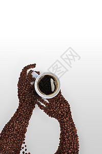 创造的咖啡豆艺术由烤咖啡豆制成的人手,灰色背景上着咖啡杯图片