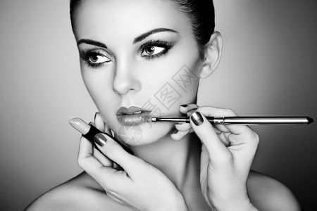 化妆师涂口红漂亮的女人脸完美的妆容黑白相间图片