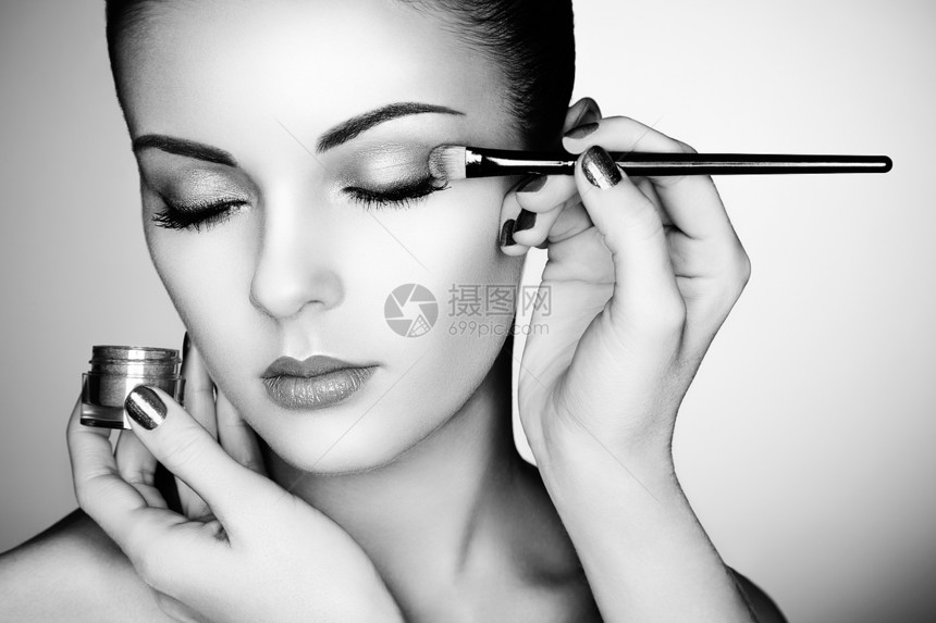 化妆师应用眼影漂亮的女人脸完美的妆容黑白相间图片