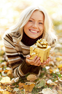 女人带着礼物躺干燥的秋叶上天赋的女人图片