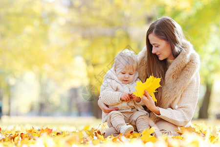 秋天公园的母亲孩子母亲孩子秋天的公园里玩得很开心图片