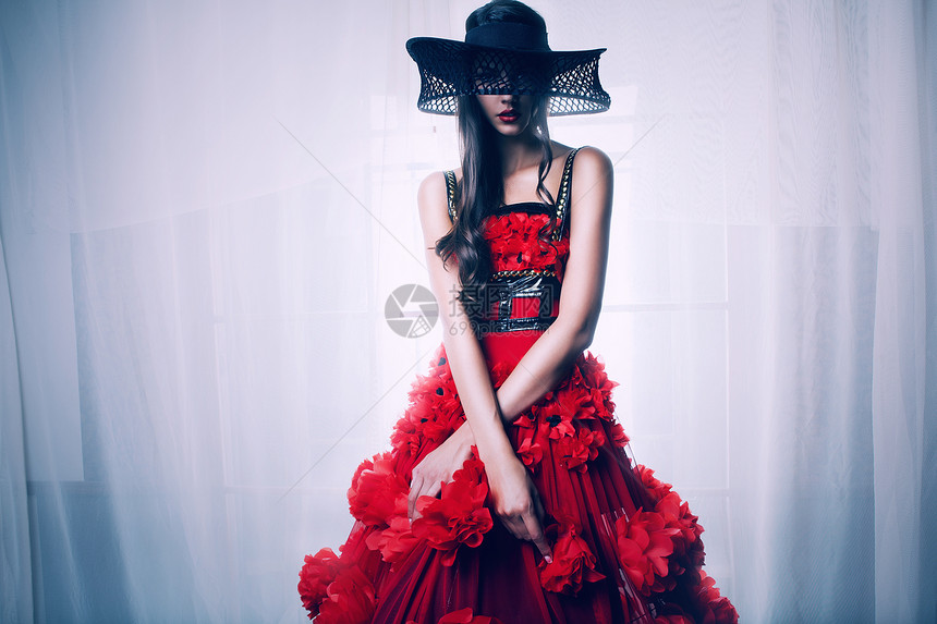 穿着红色连衣裙黑色帽子的黑发女人图片