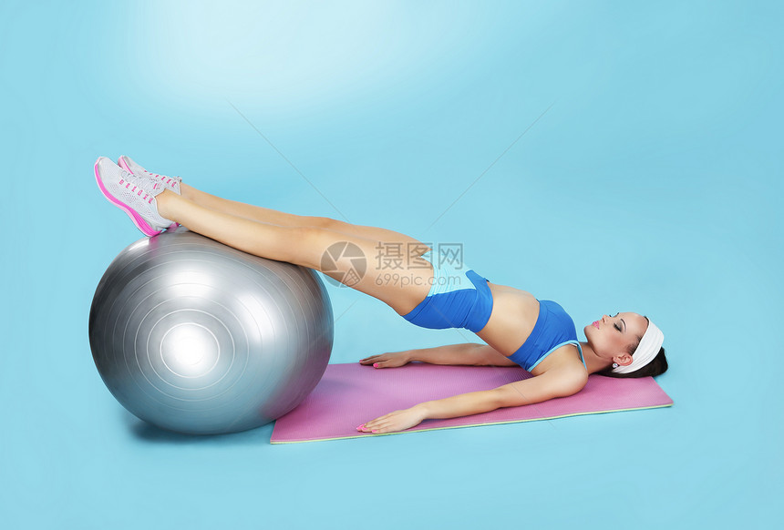 腹部运动带健身球的运动女人图片