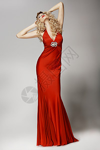 穿着红色连衣裙摆姿势的诱人的身材女人图片