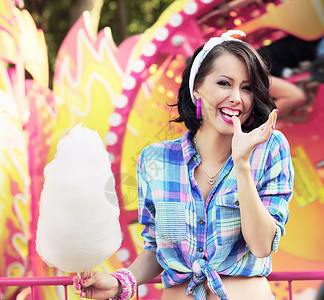 牙齿般的微笑游乐园里棉花糖的轻女人图片