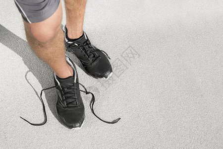 低段运动男子与解开鞋带站街上图片
