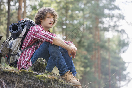 全长体贴的男背包客森林的悬崖上放松背景图片