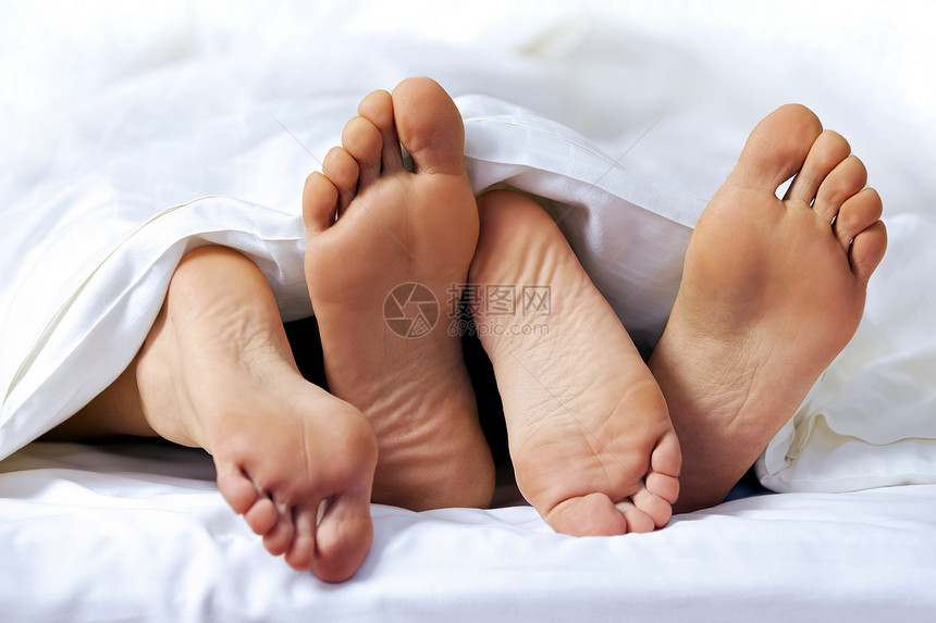 床上夫妇的脚的特写图片