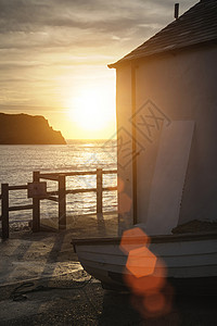 美丽的日出后的渔屋卢沃思湾增加镜头耀斑高清图片