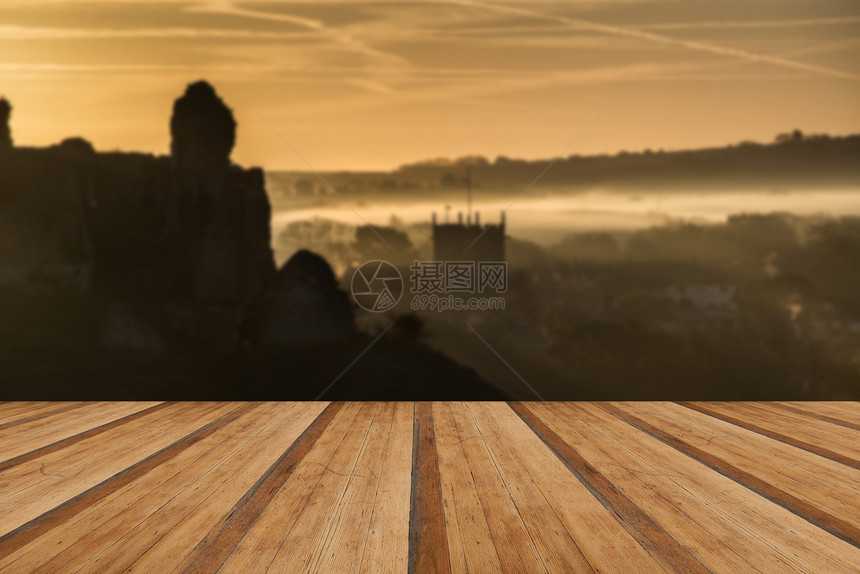 充满活力的日出中世纪城堡遗址与雾乡村景观与木制木板地板图片